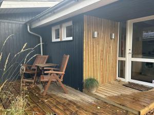 un patio con 2 sedie e un tavolo su una casa di Holiday Home Gretl in Western Jutland by Interhome ad Arrild