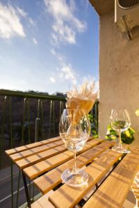 two wine glasses sitting on a wooden table on a balcony at Cozy Panorama Apartment next to the Buda Castle in Budapest