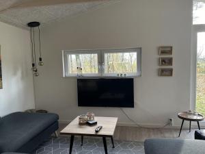 a living room with a couch and a flat screen tv at Holiday Home Gretl in Western Jutland by Interhome in Arrild