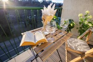 a wooden table with wine glasses and a book at Cozy Panorama Apartment next to the Buda Castle in Budapest