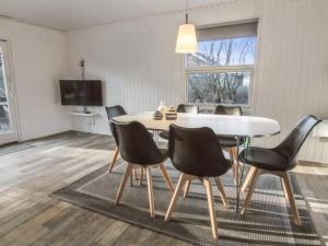 comedor con mesa blanca y sillas negras en Holiday Home Tancred - 30km from the sea in Western Jutland by Interhome en Toftlund