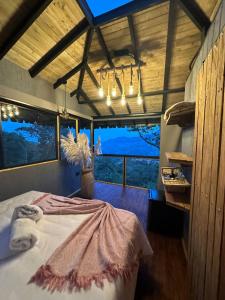 a bedroom with a bed and a large window at Ecohotel Tierra de Agua in Cocorná