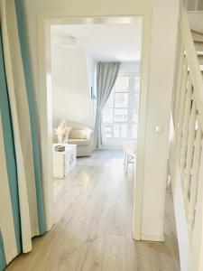 an open doorway to a living room with white walls at Maisonette-Fewo unter Reet, 50m zum Meer, Strandidyll Zingst in Zingst