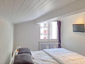 1 dormitorio con cama y ventana en Apartment Violettes-Vacances A-B-C-7 by Interhome en Crans-Montana