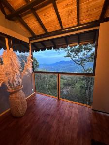 a room with a large window with a view of the mountains at Ecohotel Tierra de Agua in Cocorná