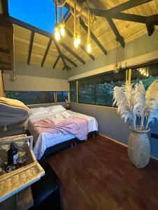 a bedroom with a bed and a vase with a plant at Ecohotel Tierra de Agua in Cocorná