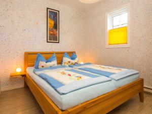 ツィノヴィッツにあるApartment Flaschenpost by Interhomeのベッドルーム1室(大型木製ベッド1台、青い枕付)