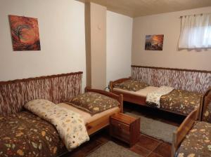 Habitación con 3 camas y sofá. en Chalupa Majer Biffar, en Dunajský Klátov