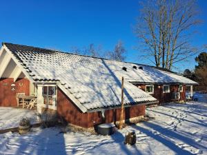 ØrstedにあるHoliday Home Alger - 450m from the sea in Djursland and Mols by Interhomeの屋根に雪が積もった木造家屋