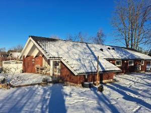 ØrstedにあるHoliday Home Alger - 450m from the sea in Djursland and Mols by Interhomeの屋根に雪を積んだ木造納屋