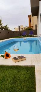 una piscina con una silla, un libro y una flor en EZITH LUXURY APARTMENTS en Heraclión