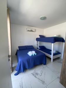 Pousada da Mel - Canasvieiras Floripa في فلوريانوبوليس: غرفة نوم بسرير ازرق وسرير بطابقين