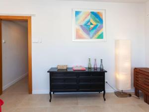a room with a dresser and a painting on the wall at Apartment Cortijo Barques by Interhome in Sitges +9 photos