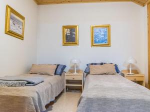 two beds in a room with two lamps on the wall at Holiday Home Teerenpesue e 37 by Interhome in Saariselka +5 photos