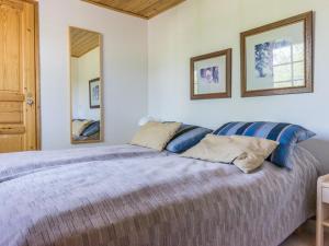 a bedroom with a bed with blue pillows and a mirror at Holiday Home Teerenpesue e 37 by Interhome in Saariselka