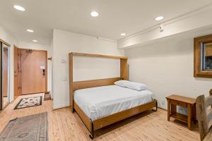 a bedroom with a bed and a table at Palisades Tahoe Lodge Rentals Studio Loft #315 in Olympic Valley +9 photos