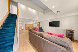 a living room with two couches and a staircase at Palisades Tahoe Lodge Rentals Studio Loft #315 in Olympic Valley