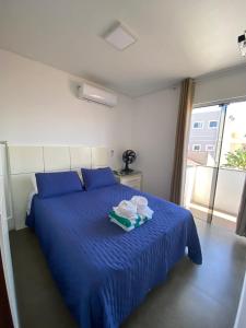 um quarto com uma cama azul com dois pratos em Pousada da Mel - Canasvieiras Floripa em Florianópolis