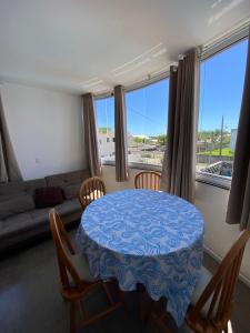 a living room with a table and chairs and a couch at Pousada da Mel - Canasvieiras Floripa in Florianópolis