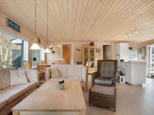 a living room with a couch and a table at Holiday Home Dwerg - 500m from the sea in NE Jutland by Interhome in Jerup