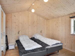 a bedroom with a bed in a wooden wall at Holiday Home Dwerg - 500m from the sea in NE Jutland by Interhome in Jerup