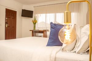 ein Schlafzimmer mit einem Bett mit einem blauen Kissen in der Unterkunft Hotel Castellana Real Cali in Cali