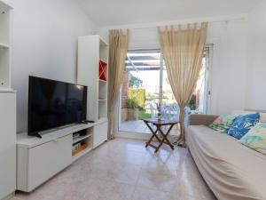 a living room with a couch and a television at Villa Tres calas 2 by Interhome in L'Ametlla de Mar
