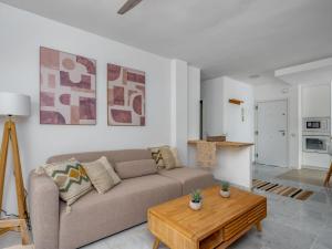 ein Wohnzimmer mit einem Sofa und einem Tisch in der Unterkunft Apartment Ático Los Pelicanos by Interhome in Manilva