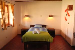 ein Schlafzimmer mit einem Bett mit zwei weißen Handtüchern darauf in der Unterkunft El Palacio de Barro in Chincheros