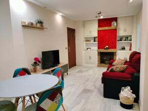 a living room with a red couch and a table at Acogedor apartamento. Mezquita Wifi in Córdoba