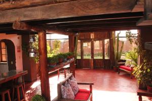 ein Wohnzimmer mit Pflanzen und roten Stühlen in der Unterkunft El Palacio de Barro in Chincheros
