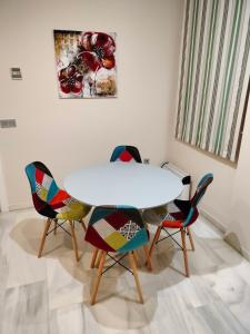 a dining room with a white table and chairs at Acogedor apartamento. Mezquita Wifi in Córdoba