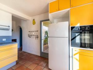 cocina con armarios amarillos y nevera blanca en Villa Les Mûriers by Interhome, en Cogolin 26 fotos más