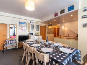 a dining room with a table and a kitchen at Apartment Les Hauts du Val Claret - Val Claret-24 by Interhome in Tignes
