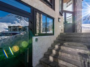 a glass door to a building with a view of the mountains at Apartment Les Hauts du Val Claret - Val Claret-24 by Interhome in Tignes