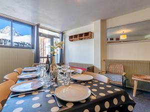 a dining room with a table with plates and glasses at Apartment Les Hauts du Val Claret - Val Claret-24 by Interhome in Tignes