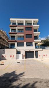 un edificio alto con un estacionamiento delante de él en Adria By The Sea - AB, en Igalo