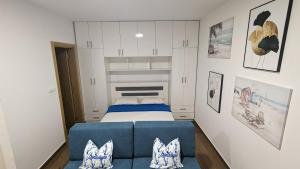 Adria By The Sea - AB في إيغالو: غرفة نوم صغيرة مع سرير وأريكة زرقاء
