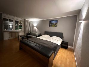 a bedroom with a bed and a chair and two windows at Altstadthotel Hayk am Rhein in Cologne