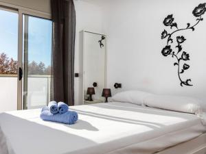 een wit bed met een paar blauwe handdoeken erop bij Apartment Mónaco by Interhome in Salou