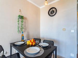 ein Esszimmer mit einem schwarzen Tisch und einer Uhr an der Wand in der Unterkunft Apartment Les Restanques Golfe Saint Tropez-9 by Interhome in Grimaud
