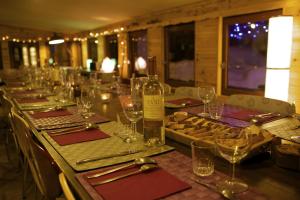 einen langen Tisch mit Gläsern und Weinflaschen darauf in der Unterkunft Le Chalet Viso in Arvieux
