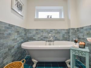 a white tub in a bathroom with a window at Holiday Home Blackmount House by Interhome in Oban