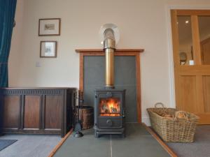 a fireplace in a living room with a stove at Holiday Home Blackmount House by Interhome in Oban