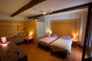 ein Schlafzimmer mit einem Bett, zwei Tischen und zwei Lampen in der Unterkunft Le Chalet Viso Auberge gite in Arvieux