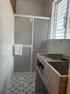 La salle de bains est pourvue d'une douche et d'un lavabo. dans l'établissement Apartamentos ANGEL'S, à Buga