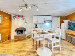 a kitchen with a white table and a fireplace at Holiday Home Köningsviken by Interhome in Sipoo