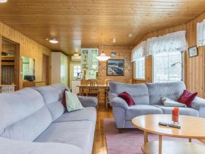 Sala de estar con 2 sofás y mesa en Holiday Home Villa heikinniemi by Interhome en Joutsa