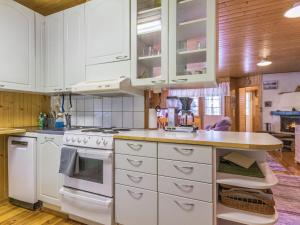 cocina con armarios blancos y encimera en Holiday Home Villa heikinniemi by Interhome, en Joutsa