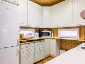 una cocina con armarios blancos y electrodomésticos blancos en Holiday Home Villa heikinniemi by Interhome en Joutsa